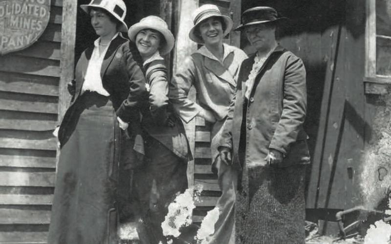 A cheeky brood of women pose outside the office of the Gold King Consolidated Mining Co. at Gladstone in 1912. Donning a hat [or a hardhat] is Cora Pitcher. Patty Slattery smiles brightly, while Maud Hartley bobs a curtsey behind Ellen Brown. San Juan Historical Society