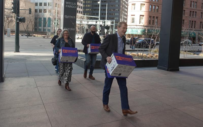 Michael Bennet &amp; his wife Susan walking in petitions with his team