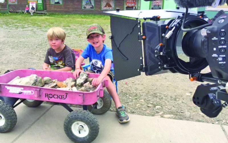 Behind the scenes shot of kids selling rocks by the train. Photo credit David Dibble