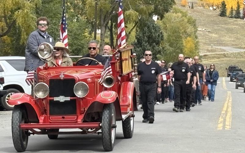 Fire Chief Gilbert Archuleta leads the funeral procession with Ron’s widow Barbara Renowden. photo by Barbara McLachlan