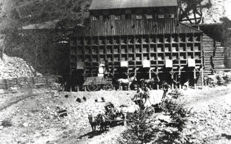 'Great Mining Revival' (1898–1910) in the Silverton district, where mining technology improved, and mineral production frequently surpassed $1 million annually. The large wooden building is a stamp mill. It utilized a gravity-fed system where raw ore was dumped into the top and processed through the gridded sections visible in the center. Courtesy of the San Juan Historical Society