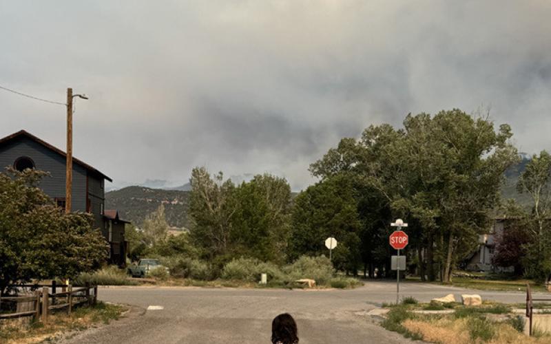 Ava Andrade on a street in Ridgway with a smoke filled horizon Photo by Katey Fetch