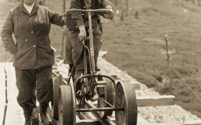 A mine bicycle on mine rail in August 1914 at the Frisco Tunnel near Animas Forks. From left are Mrs. Henson, Fred Henson and Dan McNaughton Jr.