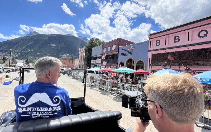 Filmmaker David Dibble films Ken Boden, owner of Handlebars, driving his Model T down main street. Photo credit DeAnne Gallegos