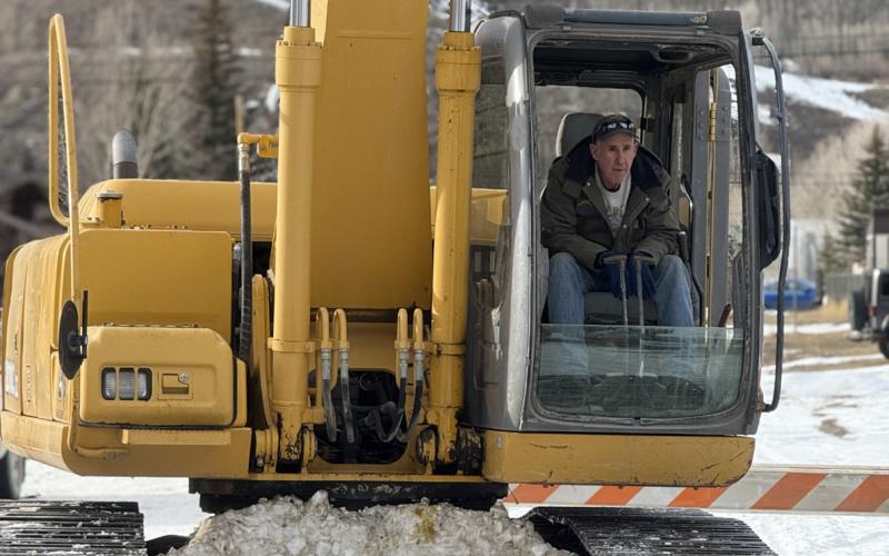 John Zarkis carefully lowers water pump into the Animas off the bridge photo by DeAnne Gallegos