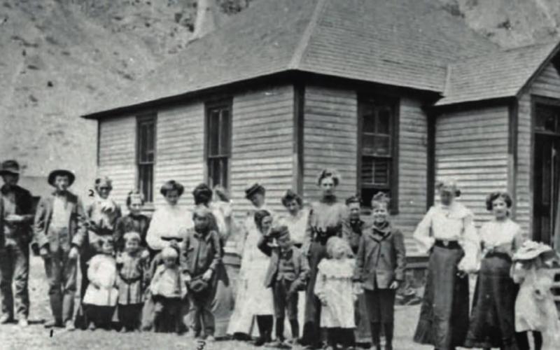 The students and staff at the Howardsville School pose in front of the school building in 1901. The photo was taken looking due north. Of the 22 people in line, only a few can be identified. Third from left is Allen Shaw, fourth from left is Luella Shaw (a taller girl), 11th from left is Clarence Shaw (in front in a straw hat), 20th from left is Nell Nelson, stepdaughter of Henry Forsyth.