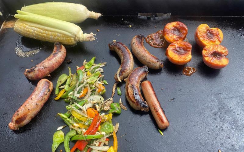 For Oktoberfest and the month of October, The Osteria on Blair Street is grilling brats, peaches, corn, and fresh veggies. Photo by Wendy Polly