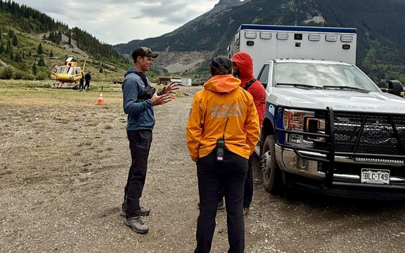 San Juan County Deputy Sheriff Adam Clifton debriefs with two Silverton Medical Rescue team members photo by DeAnne Gallegos