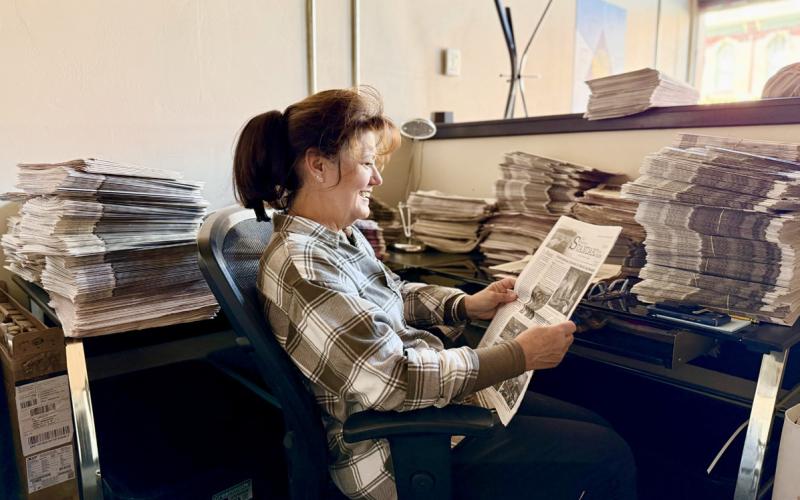 H.H. Smith's great granddaughter Susan Haupert sits in the current Silverton Standard's office and catches up on some recent newspapers photo by DeAnne Gallegos