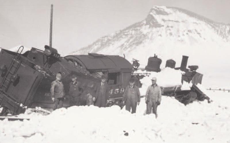 Engine 459 leans badly in deep snow with five men standing in the snow. This train derailed on the wye below Silverton on March 15, 1941. Photo: Courtesy of the Silverton Standard &amp; the Miner files.