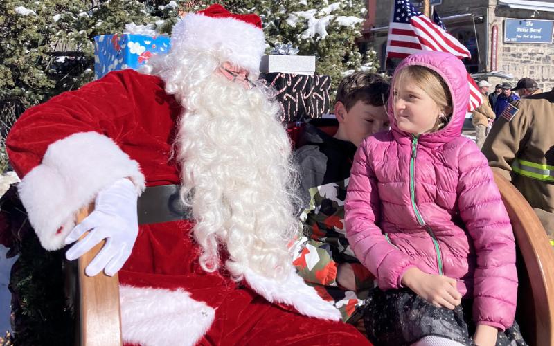 Marshall and Lilian Rodriquez sitting with Santa. Photo credit Monica Watton