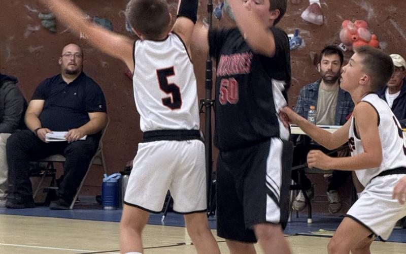 Photo by DeAnne Gallegos Ouray/Silverton (white jerseys) held a home game here in the Silverton School Gym last week, with the bleachers packed full of locals. White jersey 5 is Cash Hurt from Ouray, and white jersey to his right is Silverton local Bradford Brosh.