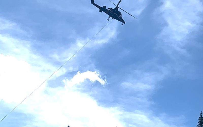 Helicopter contracted by Tri-State over Highway 550 a few miles south of Silverton headed towards Durango on Saturday, June 14th, moving tree logs out of transmission lines path. Photo credit DeAnne Gallegos
