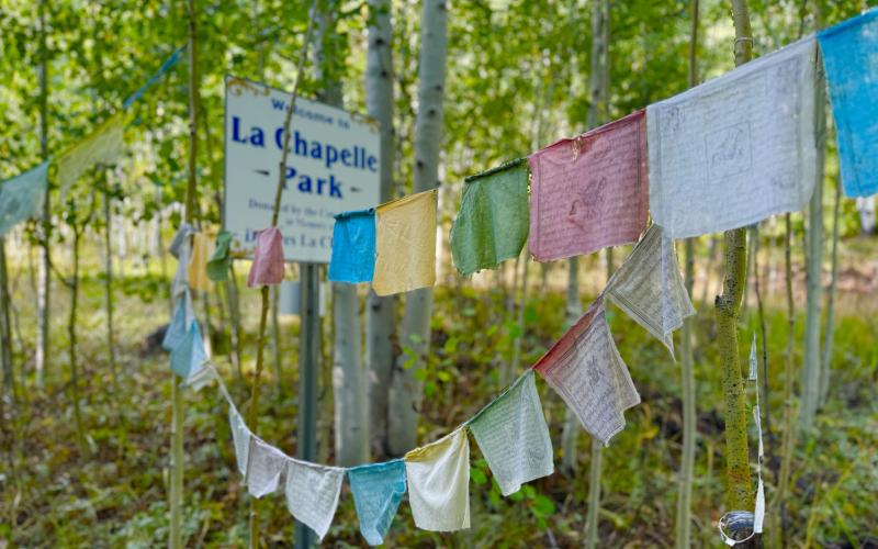 Prayer Flags hang at the sign to La Chapelle Park. Photo by DeAnne Gallegos