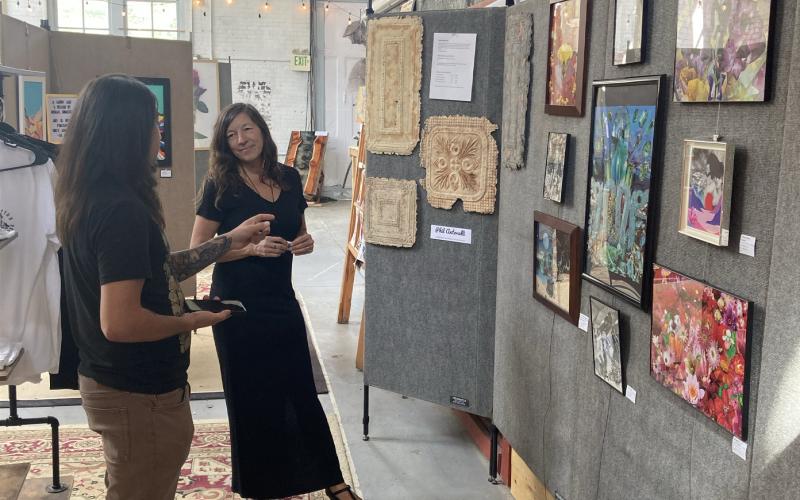 Members Art Show in August, artist Myste French discussing her work with an admirer. Photo submitted by SPC