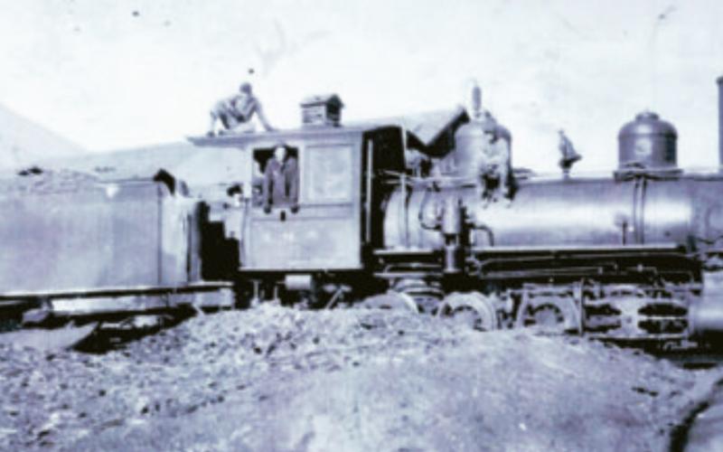 The Silverton Northern Railroad locomotive No. 3 in 1918, with the tender standing on the siding south of the Silverton Northern machine shop, facing the northeast. In the cab is William Pollman (1899-1970). John Pollman is on top of the cab. He would have been 13 in 1918. An unidentified boy is in the cab and an unidentified man is on the boiler. Photo courtesy of San Juan County Historical Society