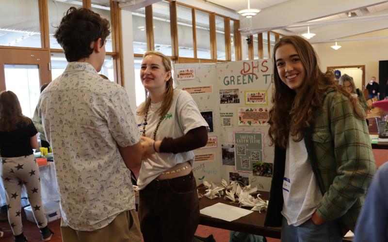 Student listens to poster presenters talk about their Durango Green Team project