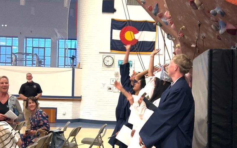 Graduates throw their caps after they received their diplomas. Photo credit DeAnne Gallegos