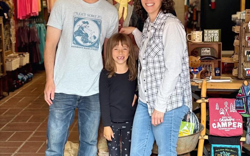 Wyatt Carmack, Anyela Carmack, and Gina Rosato pose with the old miner inside the new Timberline Trading. Photo credit Gina Rosato