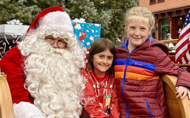 photo by Anne Izard Two local girls, Val Anderson and Elida Mead, visit with Santa together because they are besties