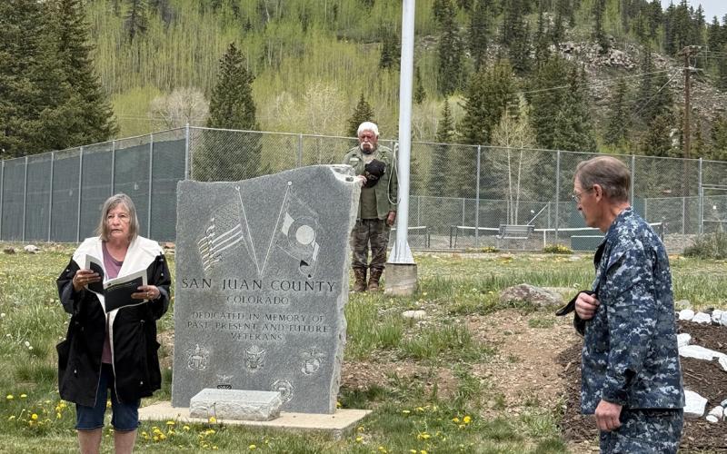 Sue Sanders reads a prayer during the Veterans Ceremony on Memorial Day. Gary Davis to right and Tom Horton in back photo by DeAnne Gallegos