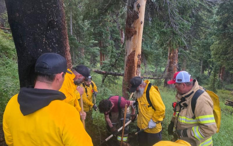 Volunteer fire department members ensuring tree fire is out photo by JP Stanley
