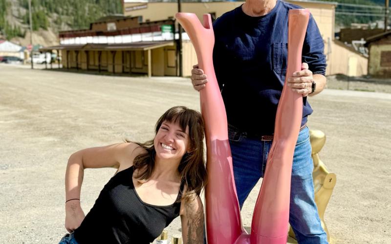 Holly Huebner of Nomad shop and Ken Boden of Handlebars horse around while painting her new shop displays