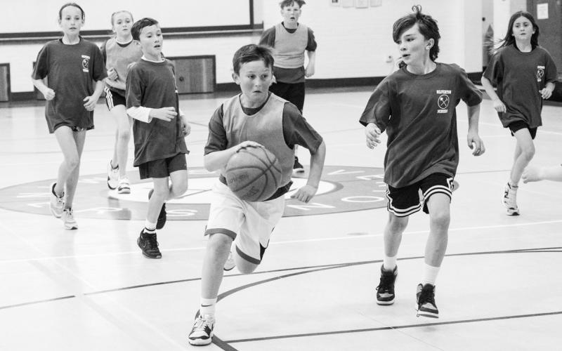 Photo credit Dave Emory Will Kranker drives down the court also pictured, Theo Kranker, Maya Foster, Lily Rodriguez, Hawkins Mead, Val Anderson, and Bradford Brosh.