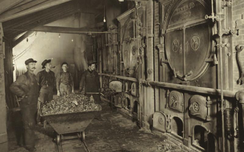 The main boiler room at the Gold King Mine in 1906. The photo shows three men around a coal car, and a fourth man shoveling coal into the firebox. The boiler tanks bear ornate endings, with the wording “the Gold King Consolidated Mines Co., 1900/Star Boiler Works.” Photo courtesy of San Juan County Historical Society