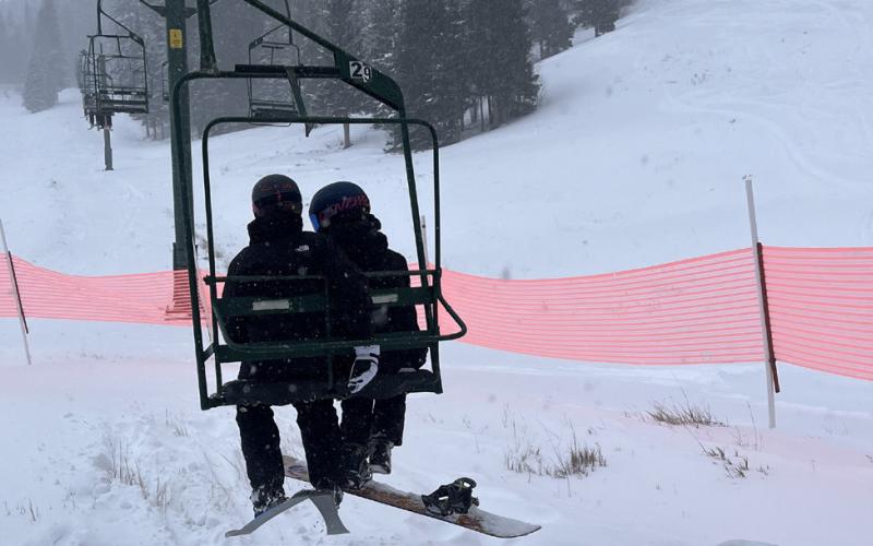 Cozy on the lift as snow falls around them Photo by Scott Fetchenhier