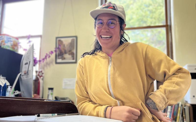 Evan Harris, a library assistant enjoys working for the library and her big smile proves that