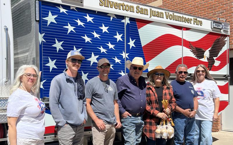 Molly Barela, Gaige Heinbaugh, Jamie Stevens, George Riley, Anna Riley, Fire Chief Gilbert Archuleta &amp; Melanie Barger all gather in front of the fire house to celebrate big donations to the 4th of July fireworks show. Photo credit DeAnne Gallegos