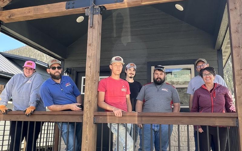 Transportation crew with Darlene and Mark Watson standing on pri-See vate porch of tiny home. Photo credit DeAnne Gallegos