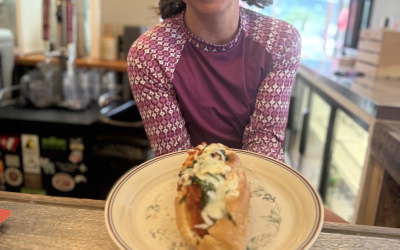 Megan Brosh shows off their newest made to order sub, “My Cousin Amie,” which features meatballs, marinara, mozzarella&amp; fresh basil. Photo credit DeAnne Gallegos