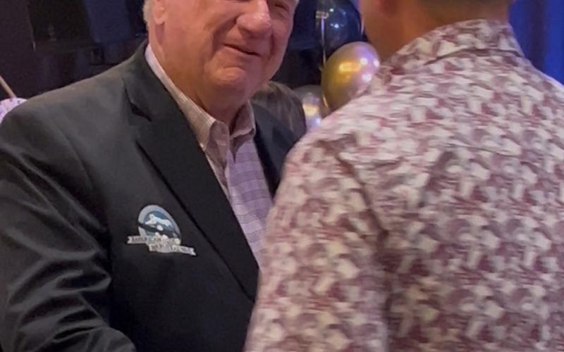 Al Harper greets one of a couple hundred surprise birthday attendees with a warm smile and handshake. Photo credit DeAnne Gallegos
