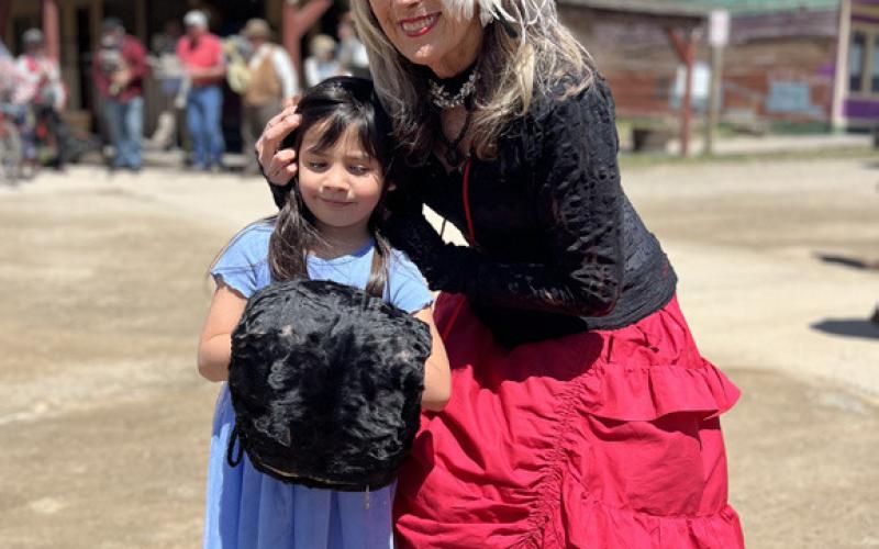 Miss Kitty poses with a young lady here visiting her grandparents, who live in town. Photo credit DeAnne Gallegos