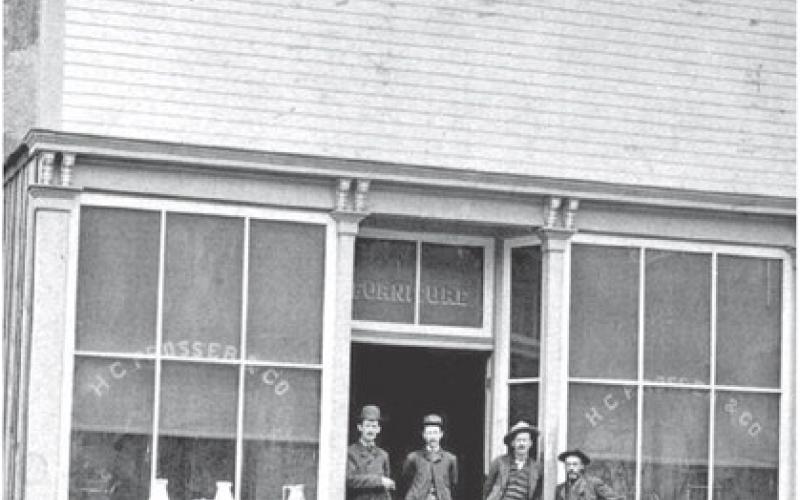Photo courtesy of San Juan County Historical Society The Prosser Building at 1121 Greene Street was opened for business in June 1183, with Horace Greeley Prosser operating a furniture store and undertaker service. The building is now home to San Juan Sweets, next door to the Brown Bear Cafe. In the background can be seen the old wood-frame Silverton School which was building in 1884.
