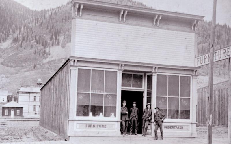 The Prosser Building at 1121 Greene Street was opened for business in June 1883, with Horace Greeley Prosser operating a furniture store and undertaker service. The building is next door to the Brown Bear Cafe. In the background can be seen the old wood-frame Silverton School which was built in 1884. Photo Courtesy of the San Juan Historical Society