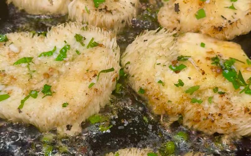 Thick cut slices of lions maine mushrooms sauting in hot butter Photo by Angelina Noble