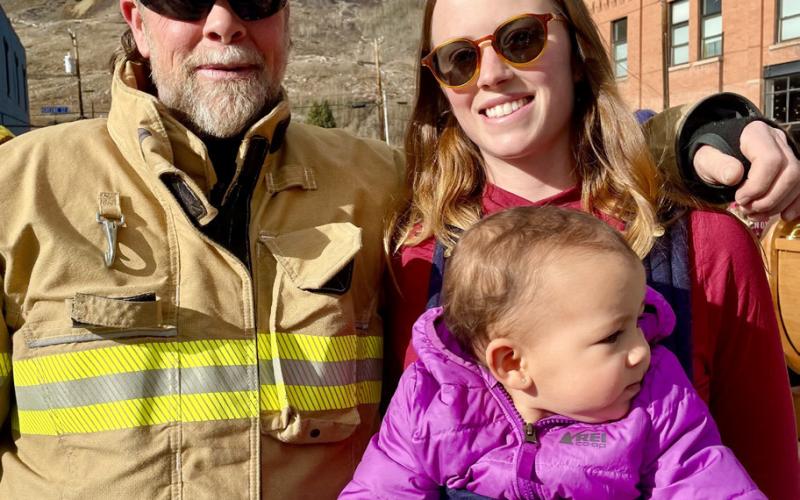 Silverton Volunteer Firefighter Carson Mordecai poses with his daughter Meah and granddaughter Katrina at the Christmas tree photo by Janice Sanders