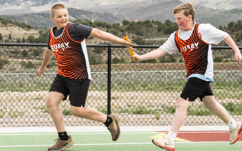 Hawkins Mead to the right passes off baton to his Ouray track teammate photo by Silverton School