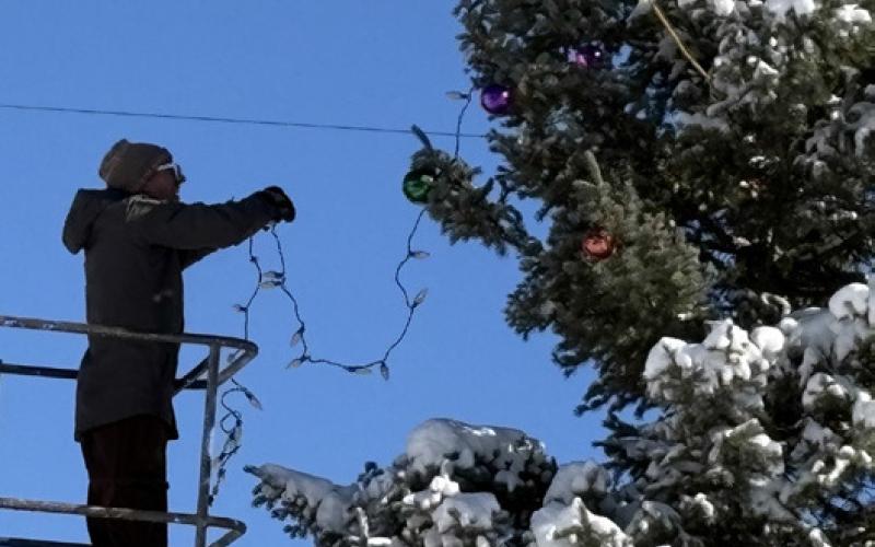 photo by Melanie Bergolc Jeff Rome uses a man lift to decorate the Christmas Tree up high