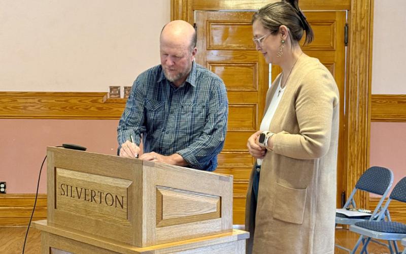Photo By DeAnne Gallegos Town of Silverton Trustee Dr. David Brown signs his Oath of Office in front of San Juan County Judge Kelly Tompkins