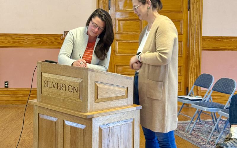 Photo By DeAnne Gallegos Town of Silverton Trustee Lindsey Halvorson signs her Oath of Office in front of San Juan County Judge Kelly Tompkins