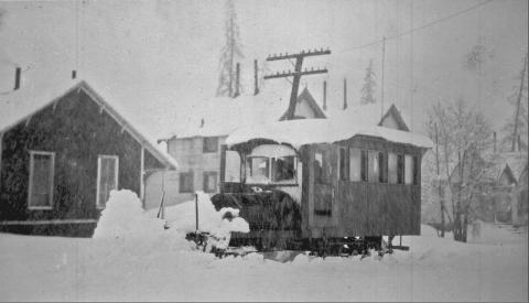 One of the George Boss stages in 1200 block of Greene Street, circa 1910. The photo shows an open buggy with at least 10 persons on it, pulled by four-horse team, facing northeast on Greene Street. The man on white horse at rear of stage is talking with someone on stage. San Juan County Historical Society photo