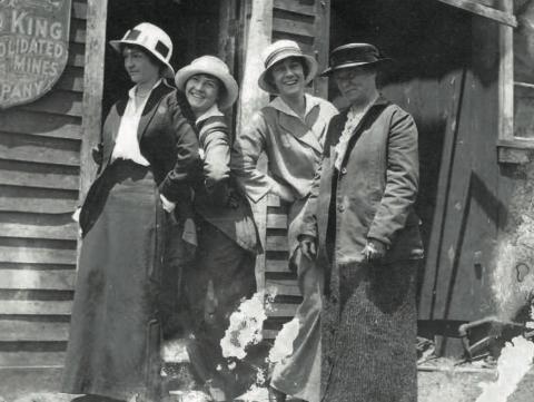 A cheeky brood of women pose outside the office of the Gold King Consolidated Mining Co. at Gladstone in 1912. Donning a hat [or a hardhat] is Cora Pitcher. Patty Slattery smiles brightly, while Maud Hartley bobs a curtsey behind Ellen Brown. San Juan Historical Society