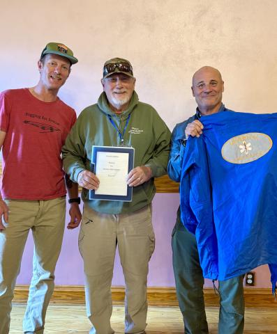 Tyler George, Kimmet Holland, and Michael Burton show off the original resume and jacket of Holland's photo by DeAnne Gallegos