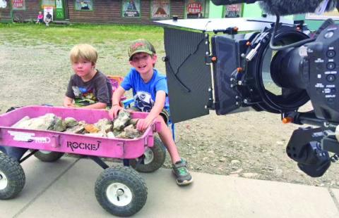 Behind the scenes shot of kids selling rocks by the train. Photo credit David Dibble