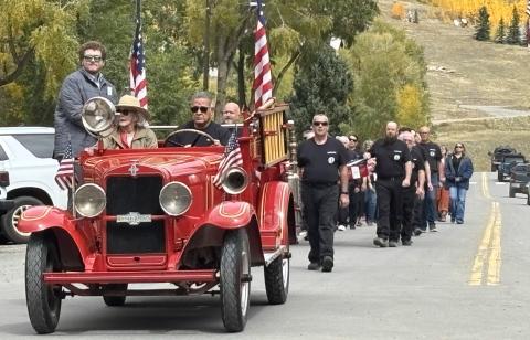 Fire Chief Gilbert Archuleta leads the funeral procession with Ron’s widow Barbara Renowden. photo by Barbara McLachlan