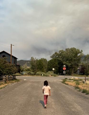 Ava Andrade on a street in Ridgway with a smoke filled horizon Photo by Katey Fetch